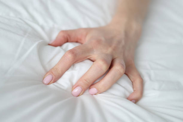 istock Woman hand squeezing white blanket at home closeup 1369540000