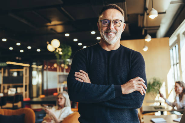 istock Mature businessman standing in a co-working space 1369540035