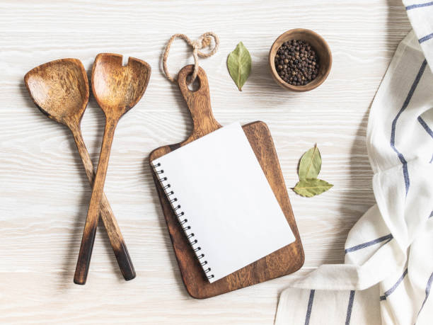 istock Minimal white kitchen background with blank notebook for text, cutting board, cotton napkin and various spices 1369542227