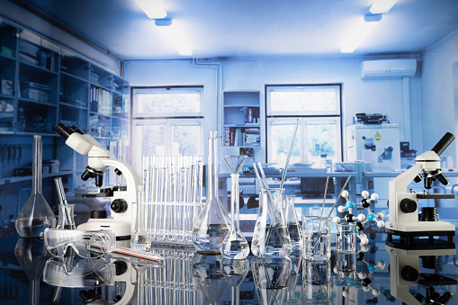 Microscope, glass tubes and beakers in the laboratory.