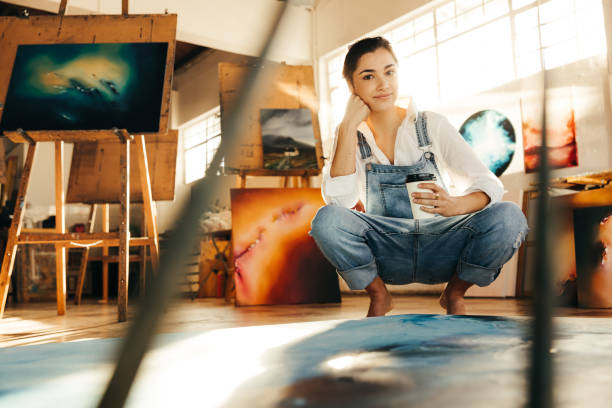 istock Freelance painter holding a cup of coffee in her art studio 1369543116