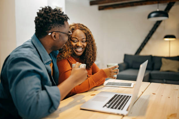 istock Young couple at home relaxing and using technology 1369543540