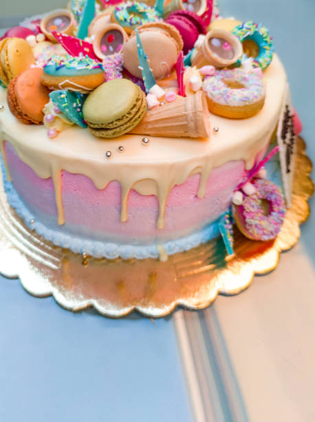istock Beautiful Birthday Cake Decorated with Colorful Macarons, Donuts, Sprinkles,.... 1369543754