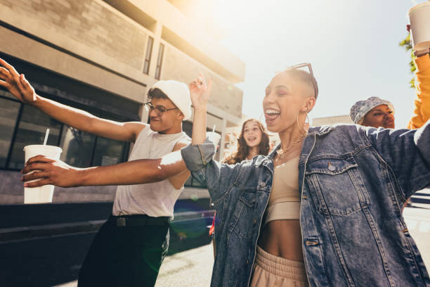 istock Young friends dancing cheerfully in the city 1369544510