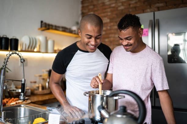 amici che cucinano insieme a casa - homosexual homosexual couple black ethnic foto e immagini stock