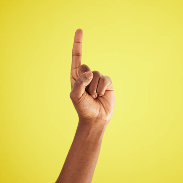 istock Studio shot of an unrecognisable man pointing upwards against a yellow background 1369545271