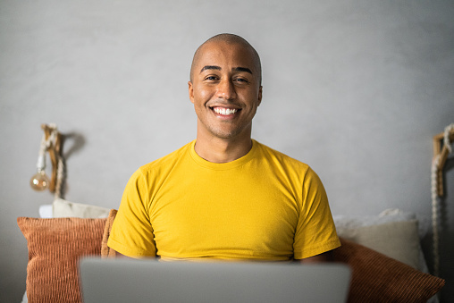 Portrait of a young man using laptop at home