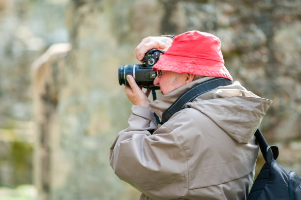 istock An elderly man uses a camera in ancient ruins. 1369546302