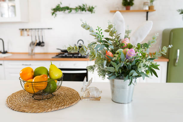 Easter bunny and flowers with eggs on white table in Scandinavian-style kitchen. Beautiful Easter greeting card