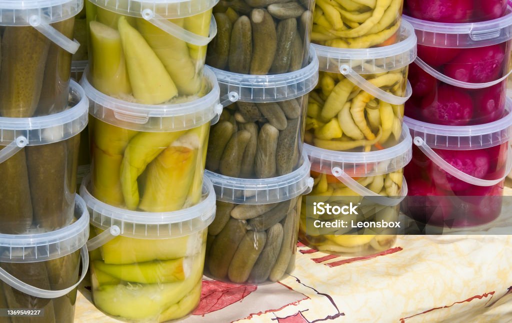 Pickled vegetables at a farmers market. Vegetables preserved by fermentation.	(Pickles, peppers, pepperoni, red onion) Bucket Stock Photo