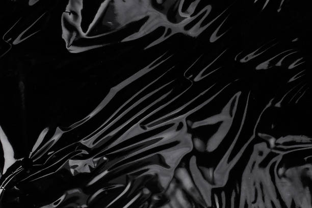 морщинистая текстура полиэтиленовой пленки на черном фоне. упаковка обоев - полиэтиленовый пакет стоковые фото и изображения