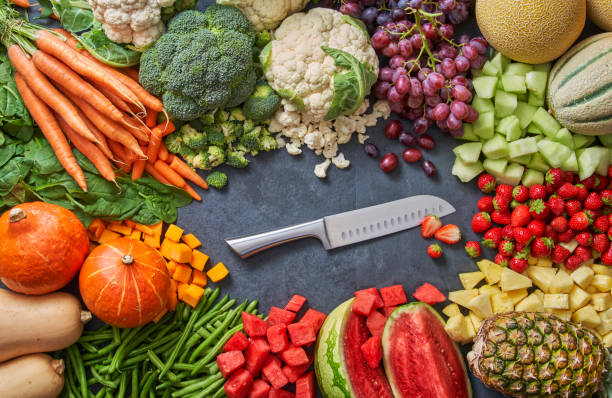 istock lots of fruit and vegetable with a knife in the middle 1369550181