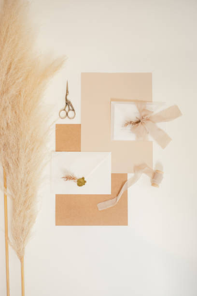 istock Vertical image peach mock up composition of paper gift envelopes with ribbons, scissors, cutting out handmade. Flat lay. 1369550677