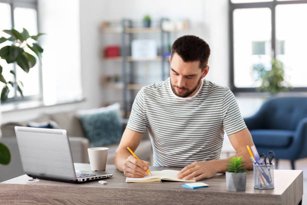 istock man with notebook and laptop at home office 1369552547