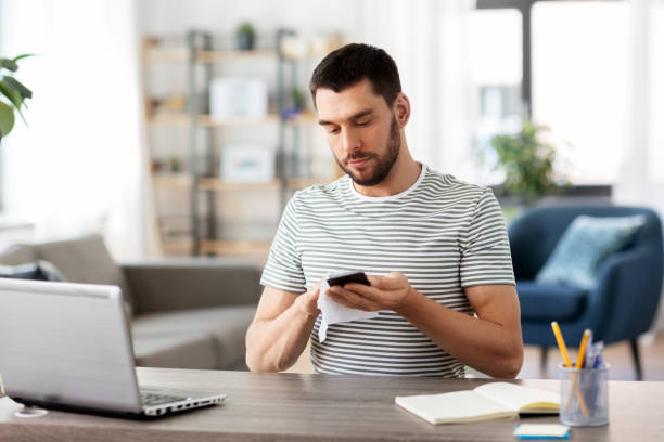 istock man cleaning phone with wet wipe at home office 1369552707