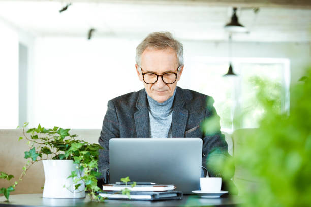 istock Senior businessman working in creative office 1369553524