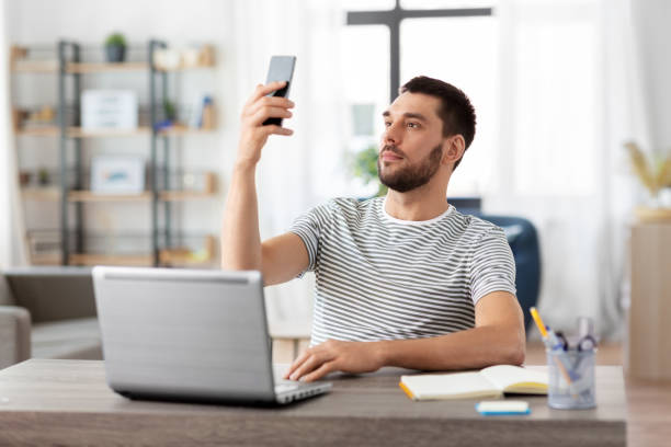 istock man with smartphone and laptop at home office 1369553703