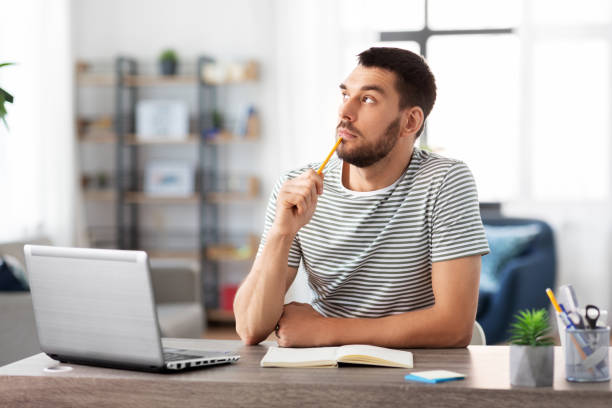 man with notebook and laptop at home office