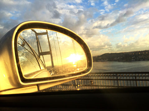 Bridge in car mirror at dusk