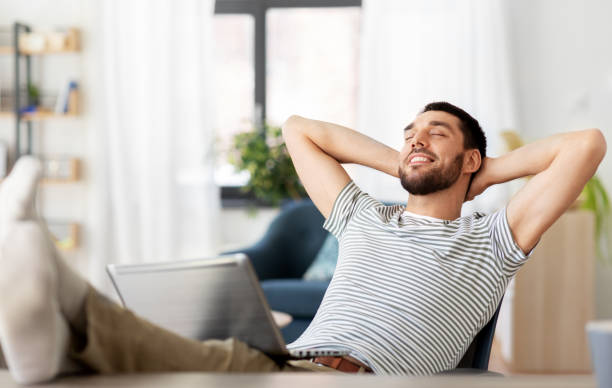 istock happy man with laptop resting at home office 1369555437
