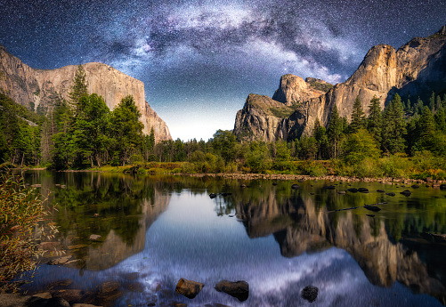 El Capitan, Half Dome, and Bridalveil Fall reflected on Merced river in Yosemite National Park at night with milky way. California. USA
