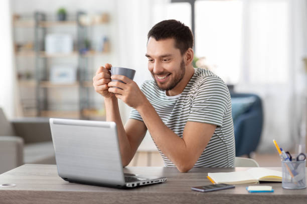 istock man with laptop drinking coffee at home office 1369555682