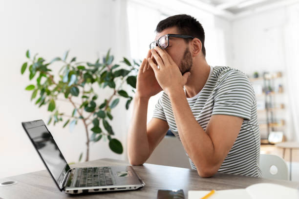istock tired man with laptop working at home office 1369555989