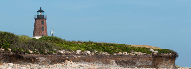 istock Point Judith Lighthouse above the sand rocks and snad dunes 1369556087