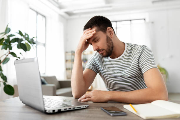 istock stressed man with laptop working at home office 1369556375