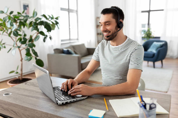 istock man with headset and laptop working at home 1369557079