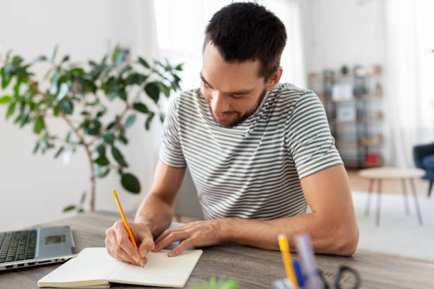 istock man with notebook and laptop at home office 1369557295