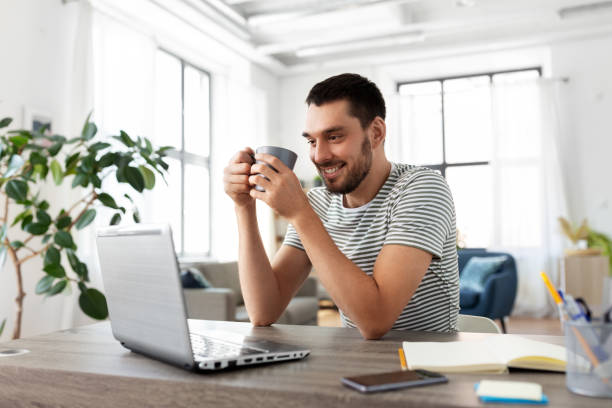 istock man with laptop drinking coffee at home office 1369557336