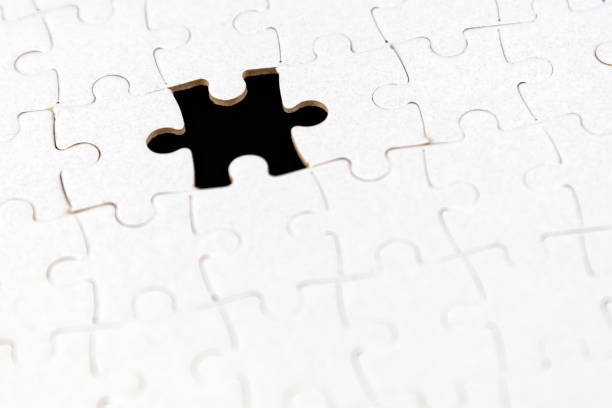 istock Background of white puzzle with missing piece on black. 1369558721