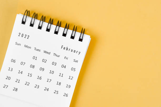 istock February 2022 desk calendar on light yellow background. 1369558863