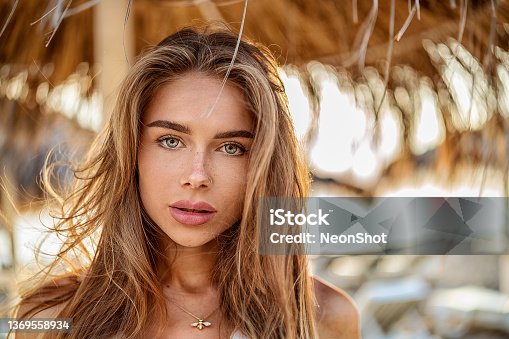 istock Portrait of natural blonde woman with freckles and long hair. Girl looking at the camera 1369558934