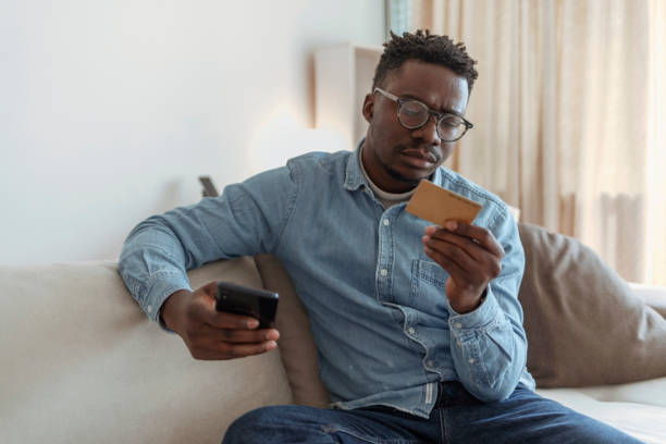 istock Handsome man having problems buying online with a credit card. 1369560933