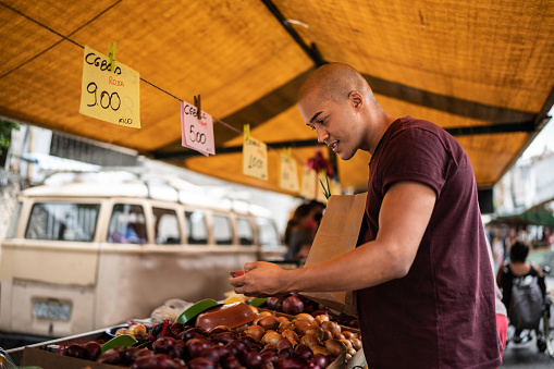Young man choosing onion at a street market