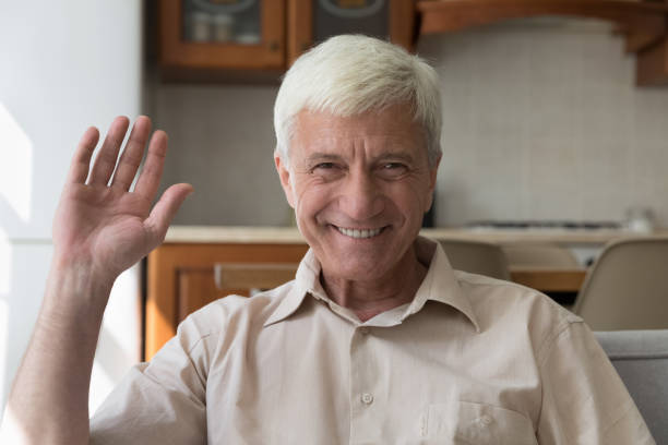 istock Happy senior 60s man smiling at camera, waving hand hello 1369567622