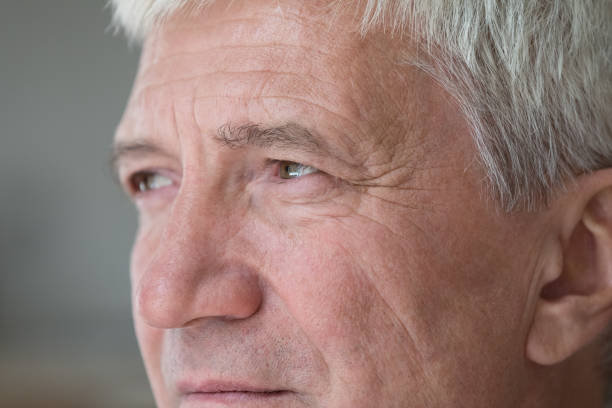 istock Serious senior middle aged man looking away in deep thought 1369567624