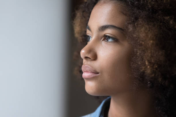 Thoughtful serious African American teen girl face portrait Thoughtful serious African American teen girl face portrait. Pretty teenager schoolgirl with perfect skin, looking away, thinking. Beauty care, skincare, youth concept serious black teen stock pictures, royalty-free photos & images