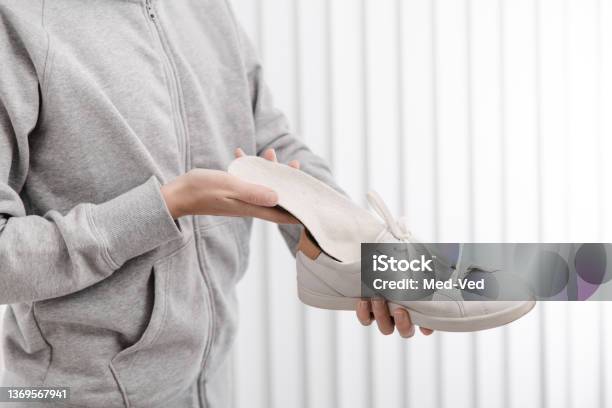 Fitness Woman In Sportswear With Orthopedic Insoles And Sneakers Woman Putting Orthopedic Insole Into Shoe At Home Close Up Foot Care Banner Flat Feet Correction Stock Photo - Download Image Now
