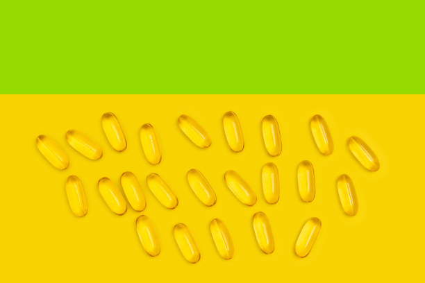 istock Omega-3 capsules nutritional supplements on yellow and green background, top view 1369568759
