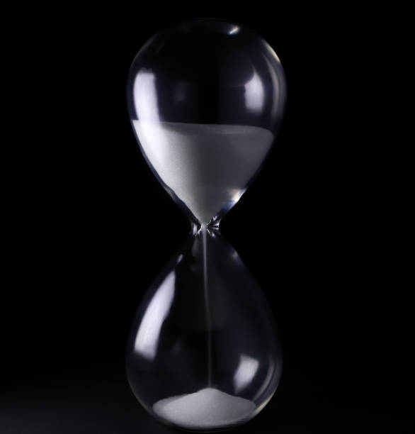 istock Hourglass with white sand showing time 1369569136