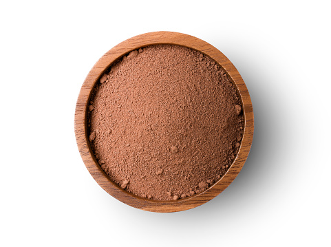 Closeup cocoa powder in wooden bowl isolated on white background with clipping path. Top view.  Flat lay.