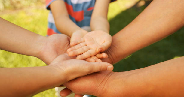 istock Shot of a boy stacking hands with his parents outside 1369569695