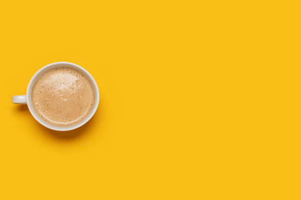 istock Single cup of coffee on yellow overhead view 1369569700