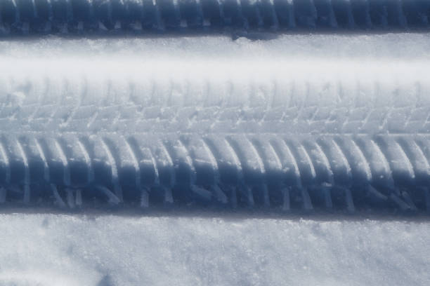 Tire track and some footprints on snow in winter season.