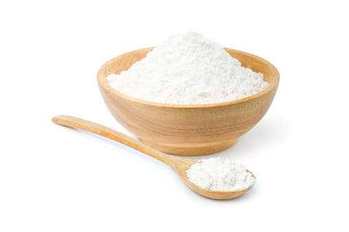 Closeup white tapioca starch (potato flour or powder) in wooden bowl and spoon isolated on white background.