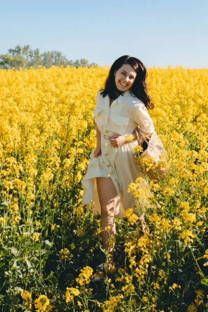 Photo of woman standing in rapeseed field