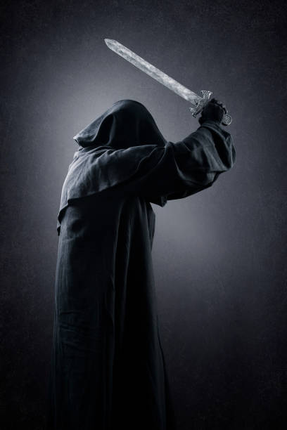 istock Warrior with hooded cape and medieval sword over dark misty background 1369572422